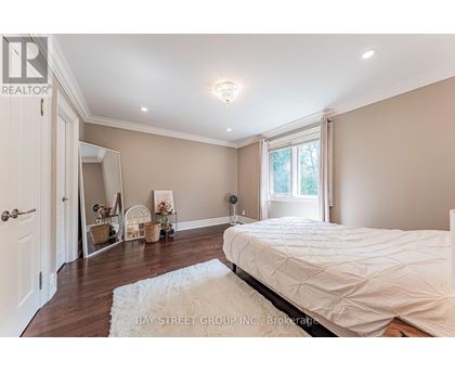 A bedroom with a large bed and a white rug.