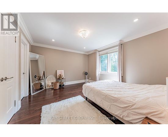 A bedroom with a large bed and a white rug.
