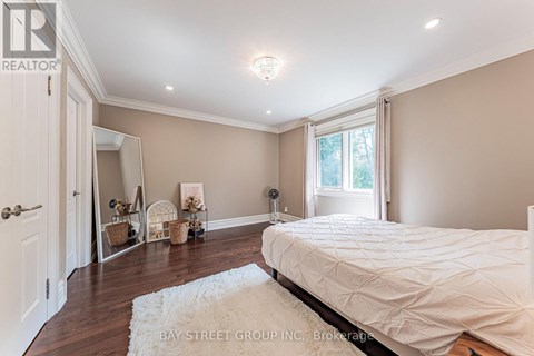 A bedroom with a large bed and a white rug.