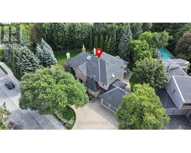 A house with a red pin on it is surrounded by trees and a pool.