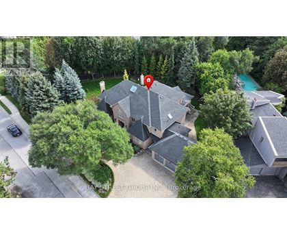 A house with a red pin on it is surrounded by trees and a pool.