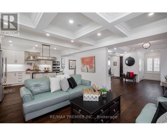 A well-lit, spacious living room with a grey sofa and a black coffee table.