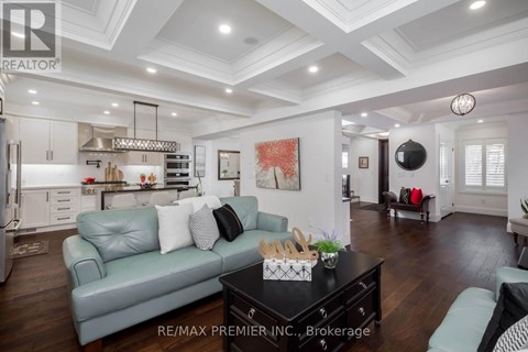 A well-lit, spacious living room with a grey sofa and a black coffee table.