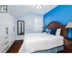 A bedroom with a white bed and a blue wall.