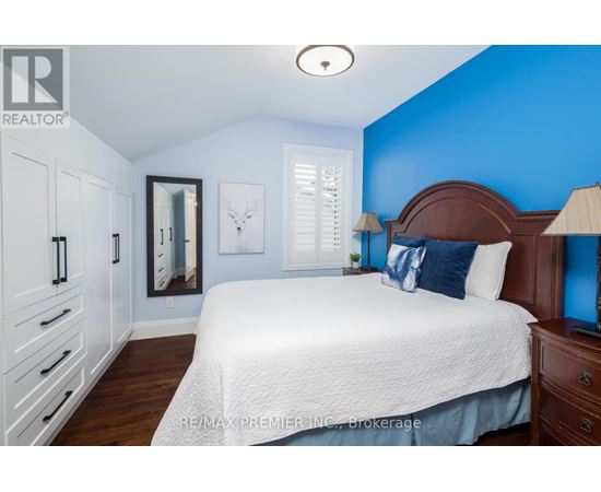 A bedroom with a white bed and a blue wall.