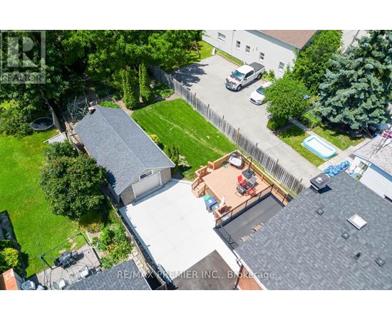 A bird's eye view of a residential area with a house, a car, and a swimming pool.