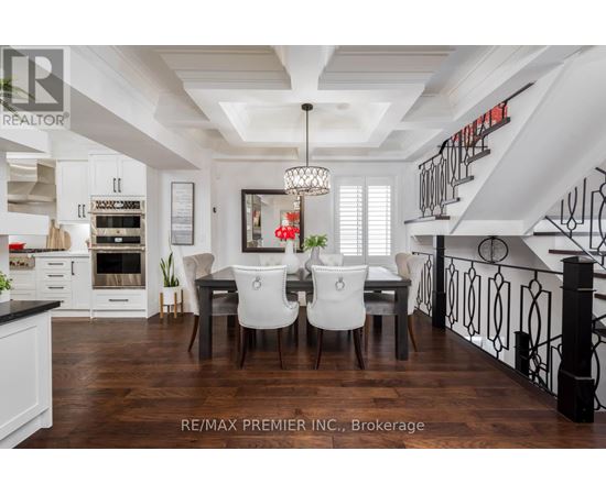 A dining room with a table set for four and a kitchen area in the background.