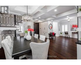 A dining room with a dark wood table and white chairs.