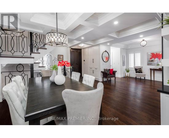 A dining room with a dark wood table and white chairs.