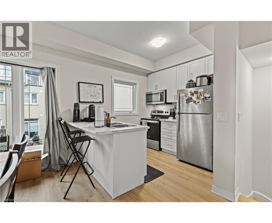 A well-lit kitchen with a dining table and chairs.