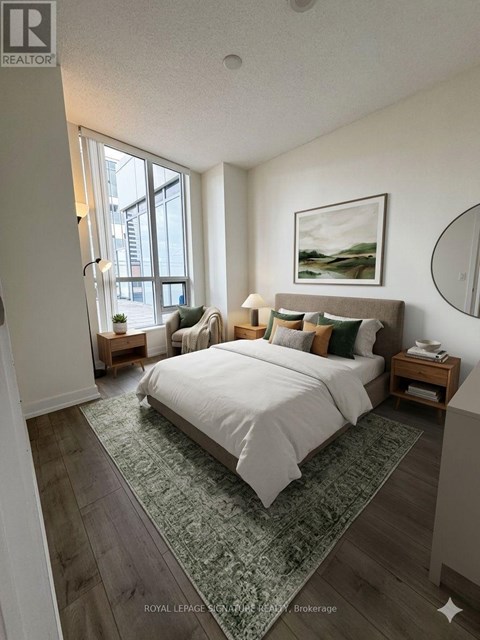 A bedroom with a large bed and a painting on the wall.