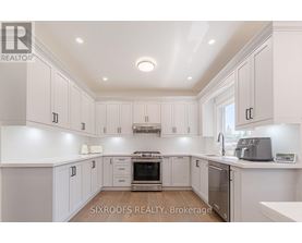 A kitchen with white cabinets and a stove top oven.