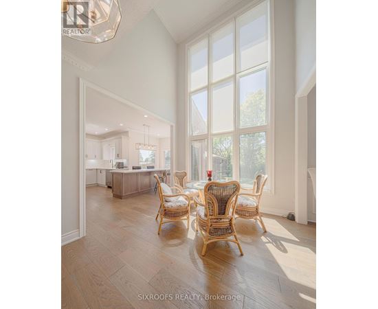 A well-lit dining room with a table and chairs.
