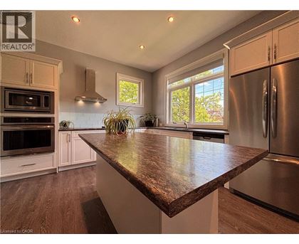 A kitchen with a brown countertop and stainless steel appliances.