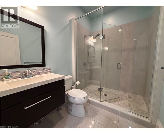 A bathroom with a toilet, sink, and shower.