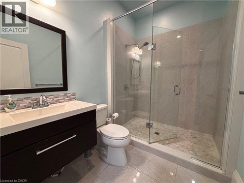 A bathroom with a toilet, sink, and shower.
