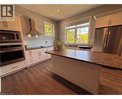 A kitchen with a refrigerator, oven, and microwave.