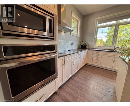 A kitchen with white cabinets and a stainless steel oven.