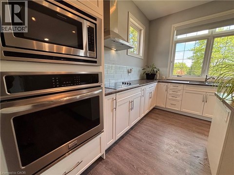 A kitchen with white cabinets and a stainless steel oven.