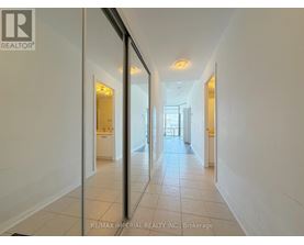 A long hallway with white walls and tiled floors.