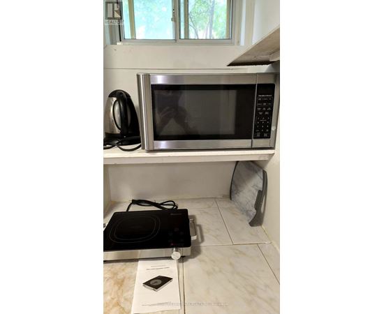 A black microwave oven is on a kitchen counter.