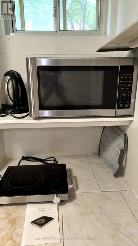 A black microwave oven is on a kitchen counter.