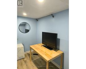 A flat screen TV on a wooden stand in a room.