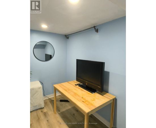 A flat screen TV on a wooden stand in a room.