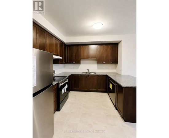 A kitchen with brown cabinets and a granite counter top.