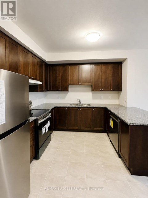A kitchen with brown cabinets and a granite counter top.