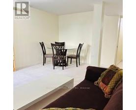 A living room with a couch, chairs and a dining table.