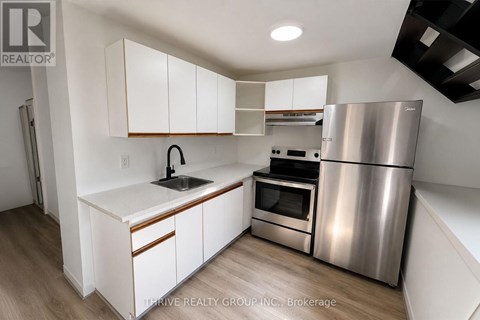 A kitchen with white cabinets and a stainless steel refrigerator.