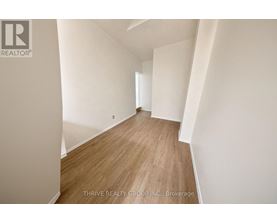 A room with wooden flooring and white walls.