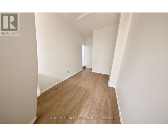 A room with wooden flooring and white walls.