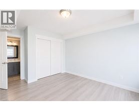 A white bedroom with a large closet and a doorway leading to a bathroom.