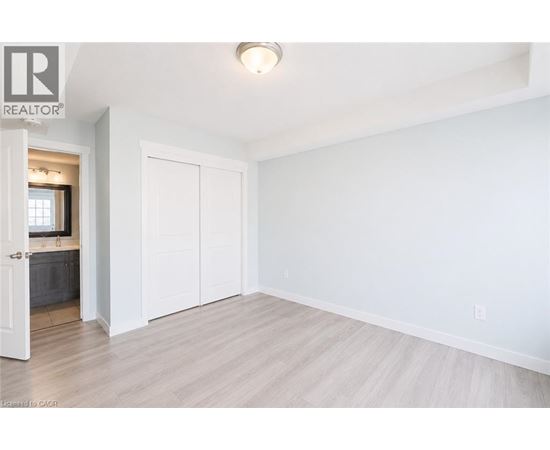 A white bedroom with a large closet and a doorway leading to a bathroom.