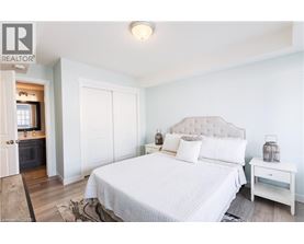 A bedroom with a large bed and a nightstand.
