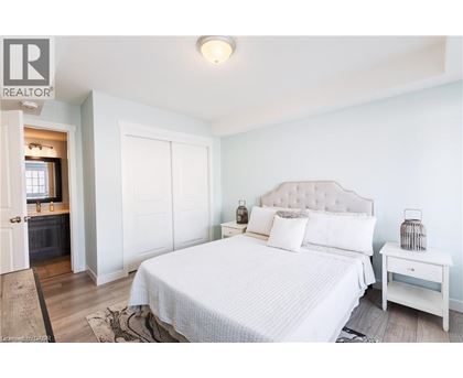 A bedroom with a large bed and a nightstand.