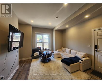 A living room with a flat screen TV mounted on the wall.