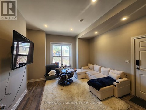 A living room with a flat screen TV mounted on the wall.