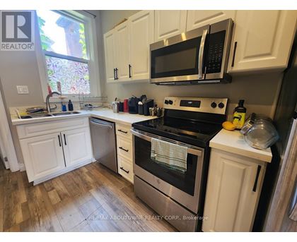 A kitchen with white cabinets and a black stove top.