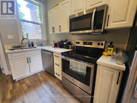 A kitchen with white cabinets and a black stove top.
