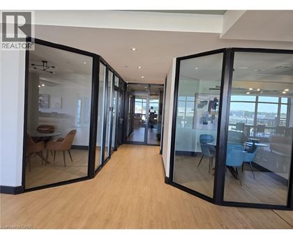 A modern office space with glass walls and wooden floors.