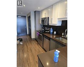 A kitchen with a wooden floor and a black counter top.