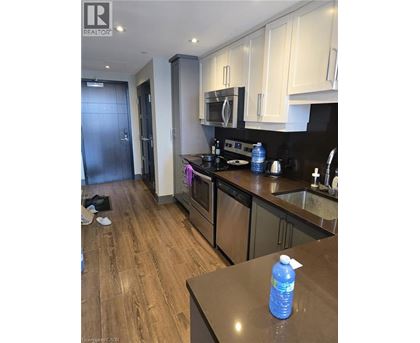 A kitchen with a wooden floor and a black counter top.