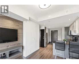 A modern kitchen with a bar stool and a television.