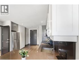 A modern kitchen with stainless steel appliances and wooden floors.
