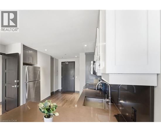 A modern kitchen with stainless steel appliances and wooden floors.