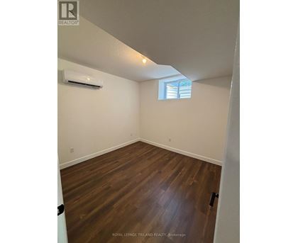 A room with wooden floors and a window with blinds.