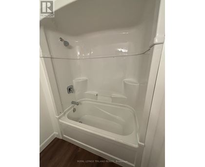 A white bathtub with a shower head and faucet.